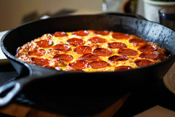 Foto de uma pizza de calabresa dentro de uma frigideira