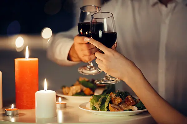 Foto de casal brindando em jantar romântico a luz de velas